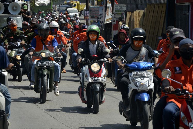 Sejumlah pendukung salah satu pasangan bakal calon kepala daerah Makassar melakukan konvoi menggunakan kendaraan menuju ke kantor Komisi Pemilihan Umum (KPU) Makassar di Sulawesi Selatan, Jumat (4/9/2020). Konvoi para pendukung pasangan bakal calon kepala daerah di Makassar masih terjadi saat pendaftaran meski sudah ada imbauan dari menteri dalam negeri agar dalam proses pendaftaran tidak diperbolehkan adanya konvoi dan melibatkan pendukung setiap pasangan bakal calon guna menghindari kerumunan massa sebagai langkah antisipasi penyebaran COVID-19.