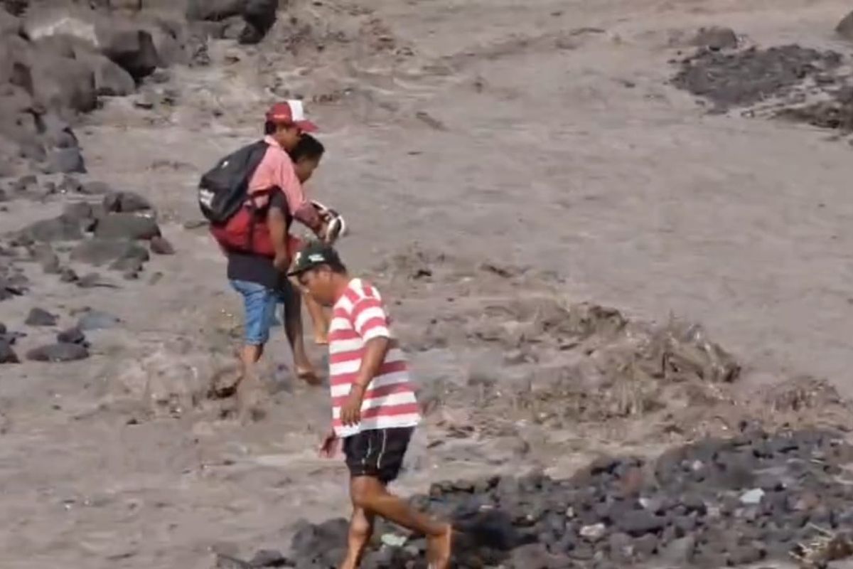 Ilustrasi siswa Sumberlangsep digendong menyebrangi aliran lahar untuk bisa ke sekolah, Kamis (4/12/2025)