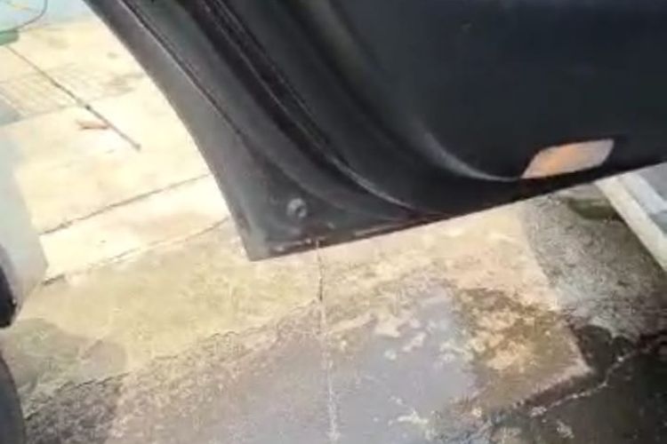 air mengucur dari lubang buangan air di pintu mobil