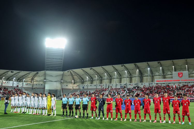 Kiri ke Kanan) Sebelas pemain Irak dan Indonesia berdiri menyanyikan lagu kebangsaan mereka sebelum dimulainya pertandingan perebutan tempat ketiga Piala Asia U23 AFC Qatar 2024 antara Irak dan Indonesia di Stadion Abdullah Bin Khalifa di Doha pada 2 Mei 2024. (Foto oleh Karim JAAFAR / AFP)