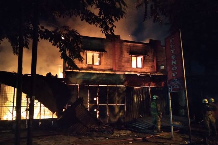 Petugas dari pemadam kebakaran Kabupaten Tangerang berupaya memadamkan api yang membakar rumah toko di Pasar Kemis, Tangerang, Rabu (15/12/2021) dini hari. 