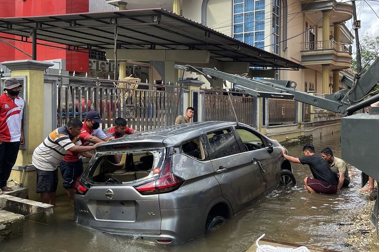 Sejumlah petugas Perumdam Tirta Senentang dan Paldam XII/Tanjungpura berupaya mengevakuasi sebuah mobil dari dalam parit di Jalan Lintas Melawi, Kabupaten Sintang, Kalimantan Barat, Jumat (19/11/2021). Mobil tersebut terseret banjir dan tenggelam di parit kemudian menimpa pipa jaringan distribusi utama Perumdam Tirta Senentang hingga mengakibatkan puluhan rumah di kawasan itu tidak mendapatkan air selama sembilan hari terakhir. ANTARA FOTO/Jane Elisabeth Wuysang/jhw/wsj.