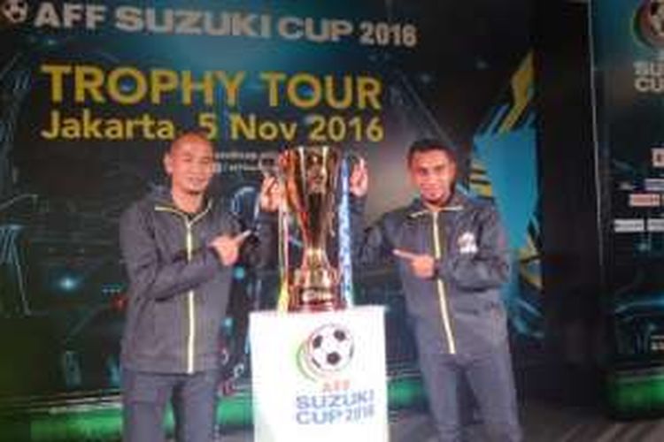 Eks penyerang timnas Indonesia, Kurniawan Dwi Yulianto (kiri), dan gelandang Sriwijaya FC, Firman Utina, berpose dengan trofi Piala AFF 2016 yang dipamerkan di kawasan fx Sudirman, Jakarta, 5 November 2016.