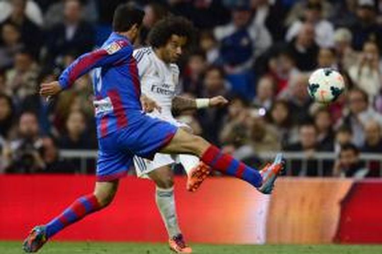 Bek Real Madrid, Marcelo, saat melepaskan tendangan yang berujung gol ke gawang Levante pada lanjutan Liga BBVA di Stadion Santiago Bernabeu, Minggu (9/3/2014). 