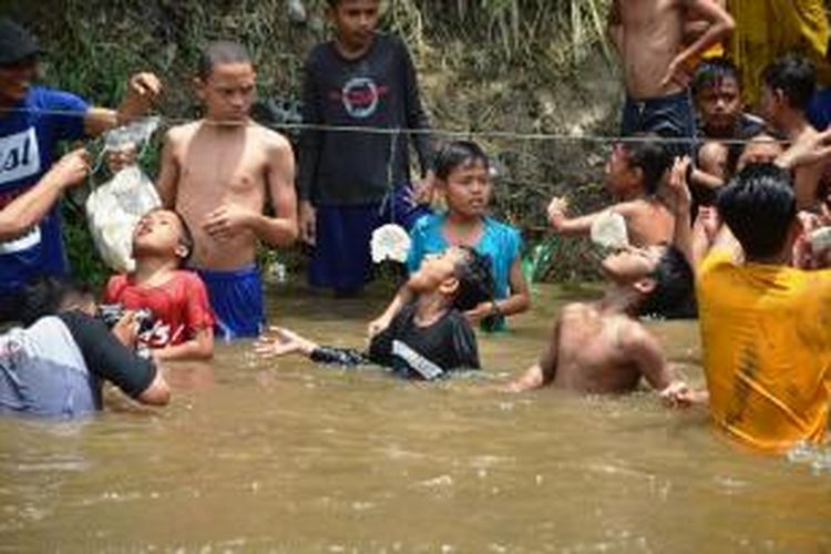 Lomba makan kerupuk sambil melawan arus Sungai Deli pada HUT ke 70 Indonesia