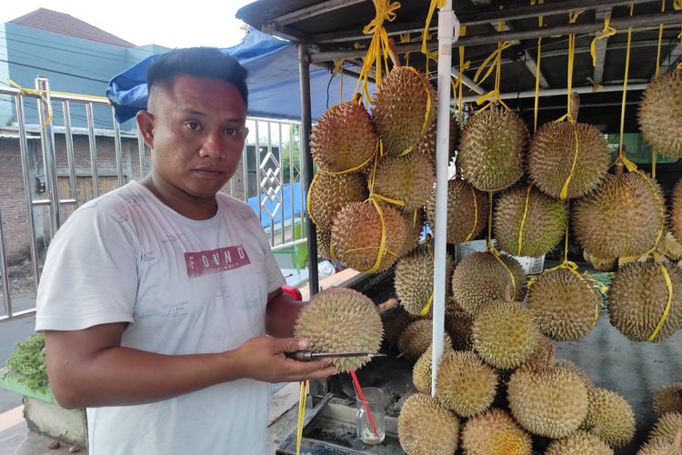Rozikin atau dikenal pedagang durian Sambo saat mangkal di depan Pasar Bintoro Demak, Jumat (26/4/2024). (KOMPAS.COM/NUR ZAIDI)