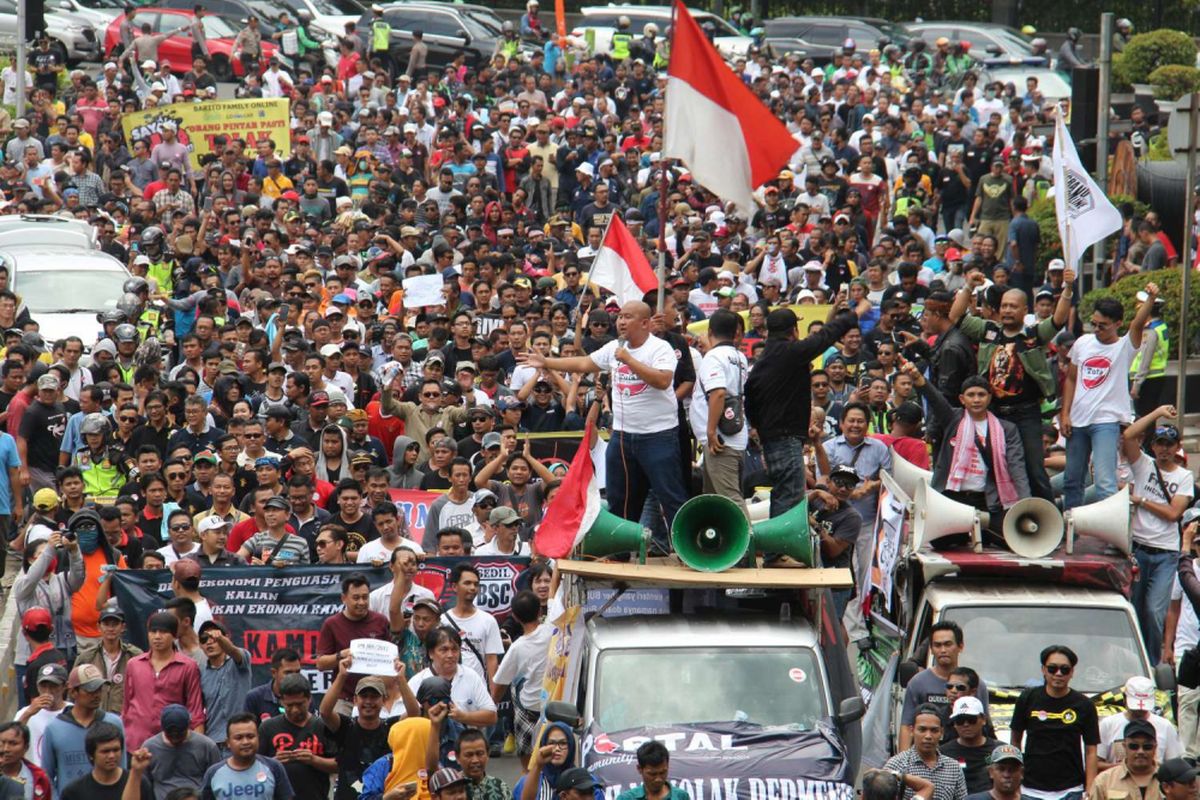 Para pengemudi taksi online dari berbagai daerah melakukan aksi unjuk rasa di depan Kementrian Perhubungan, Jalan Medan Merdeka Barat, Jakarta, Senin (29/01/2018). Mereka menolak Peraturan Menteri (PM) Perhubungan Nomor 108 penyelenggaraan angkutan orang dengan kendaraan bermotor umum tidak dalam trayek.