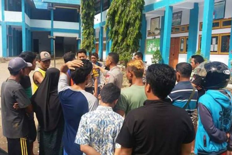 Polisi saat mengamankan tempat kejadian perkara kasus penganiayaan seorang guru SMP Negeri 11 Kota Bima, Kamis (8/6/2017)