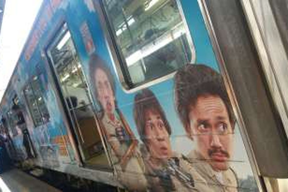 Poster Warkop DKI Reborn: Jangkrik Boss! Part 1 melapisi badan luar salah satu gerbong KRL di Stasiun Jakarta Kota, Jakarta Barat, Sabtu (20/8/2016) siang.