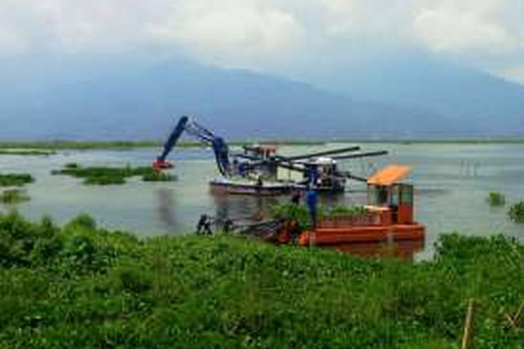 Dua kapal Aquatic tengah bekerja mengambil enceng gondok di perairan Rawapening, tepatnya di dekat dermaga Sumurup, desa Asinan, Bawen, Kabupaten Semarang, Rabu (11/1/2017) siang.