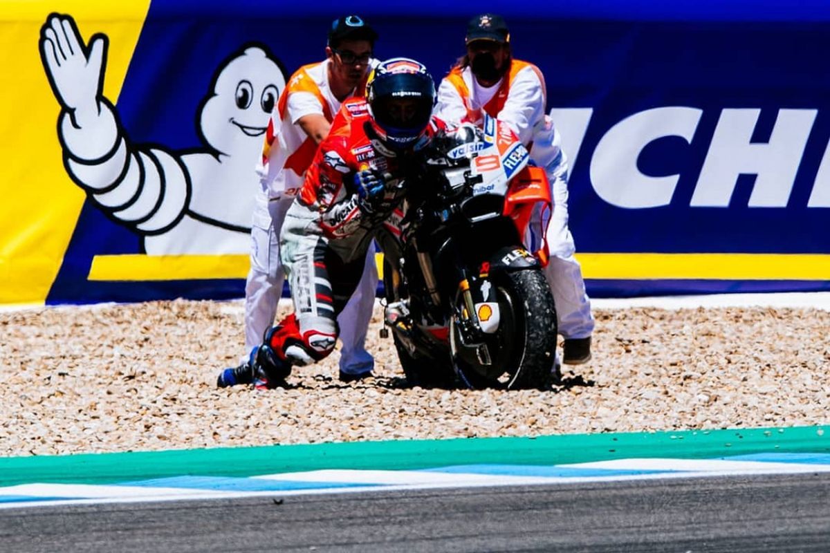 Pebalap Ducati Andrea Dovizioso salah mendorong motor usai terlibat tabrakan beruntun saat seri MotoGP Spanyol di Siruit Jerez, Minggu (6/5/2018).
