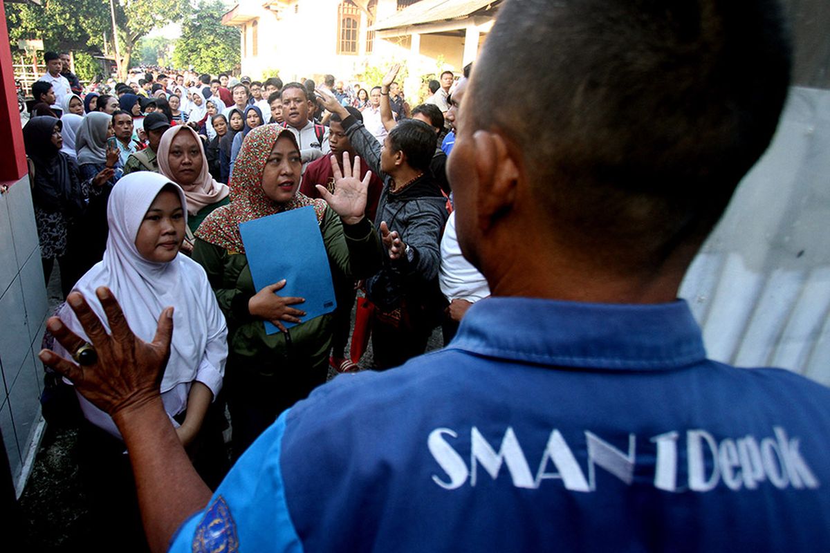 Sejumlah siswa dan orangtua murid antre saat akan mengikuti seleksi Penerimaan Peserta Didik Baru (PPDB) di SMAN 1 Depok, Kota Depok, Jawa Barat, Selasa (18/6/2019). Sistem PPDB Jawa Barat dengan mekanisme berdasarkan sistem jalur zonasi atau pemetaan wilayah sebanyak 90 persen, jalur prestasi lima persen dan jalur perpindahan orang tua wali lima persen tersebut, berlangsung dari tanggal 17-22 Juni 2019.