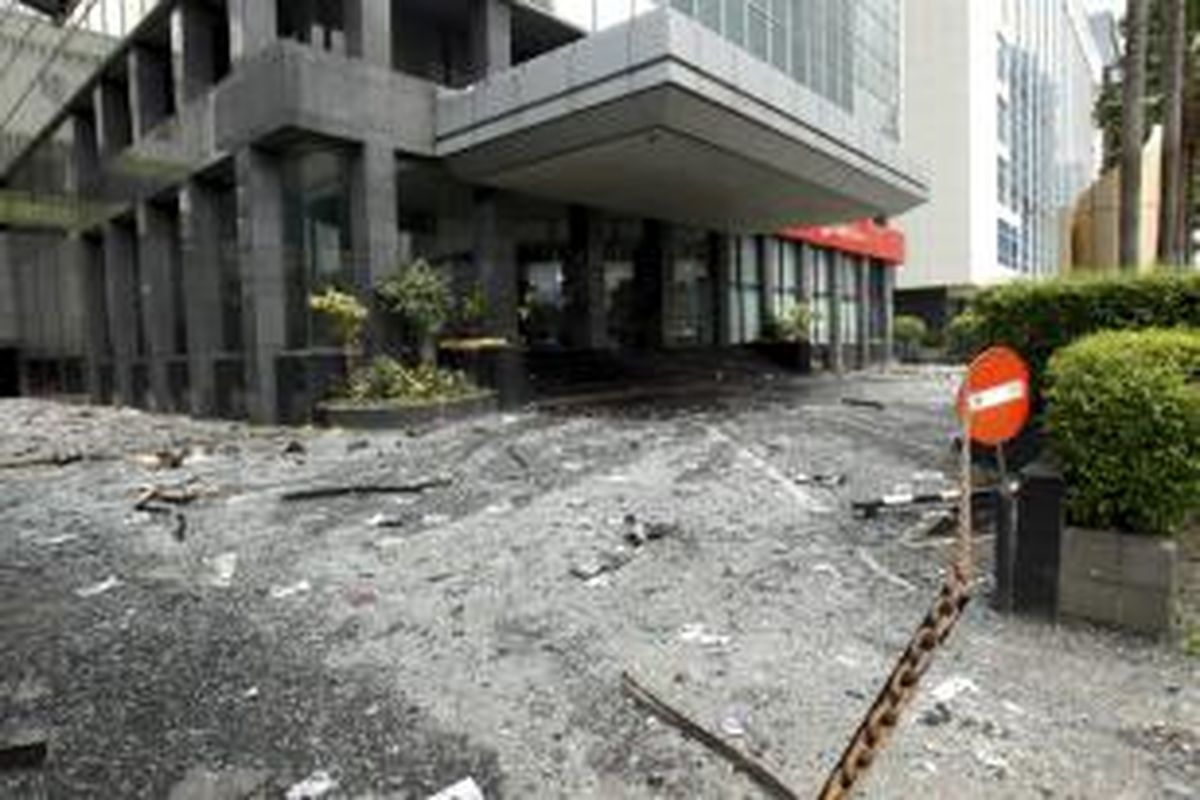 Petugas membersihkan pecahan puing kaca dan kertas yang berserakan di lokasi kebakaran di Wisma Kosgoro, Jalan MH Thamrin, Jakarta, Selasa (10/3/2015). Kebakaran yang terjadi pada Senin malam ini bermula dari lantai 16 dan merembet ke lantai 20. Penyebab kebakaran masih ditelusuri.