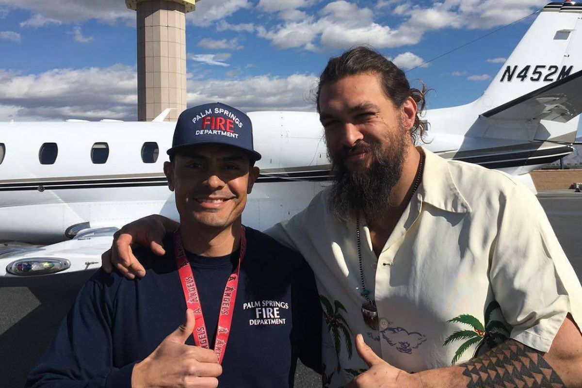 Jason Momoa bersama seorang petugas pemadam kebakaran berfoto bersama setelah pesawat yang Momoa tumpangi diduga mengalami kebakaran mesin.