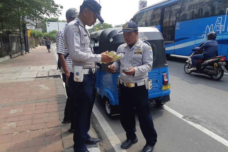 Petugas Dishub memberhentikan bajaj yang melintas di jalur sepeda jalan Tomang Raya, Jakarta Barat, Rabu (20/11/2019)