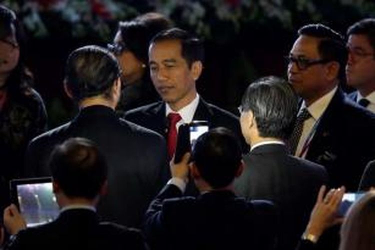 Para delegasi menggunakan smartphone, berebut selfie dengan Presiden Joko Widodo (Jokowi), usai menyampaikan pidato di acara APEC CEO Summit di China National Convention Center di Beijing, 10 November 2014.