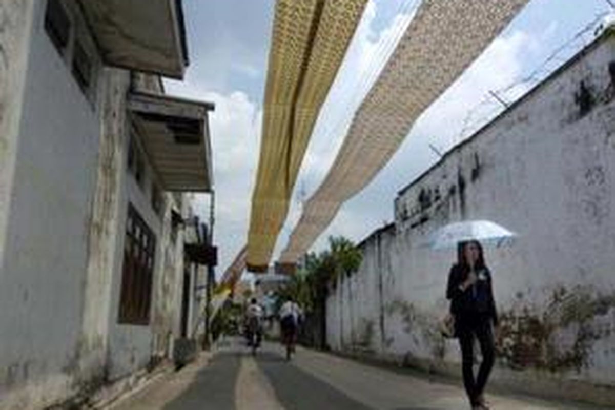 Menjaga citra Kampoeng Batik Laweyan sebagai sentra industri batik di Solo, Jawa Tengah, warga memasang kain batik di atas jalan, Selasa (18/3). Selain membuat suasana kental sebagai kampung batik, pemasangan kain tersebut juga untuk menyukseskan tahun kunjungan Laweyan atau Visit Laweyan 2008.