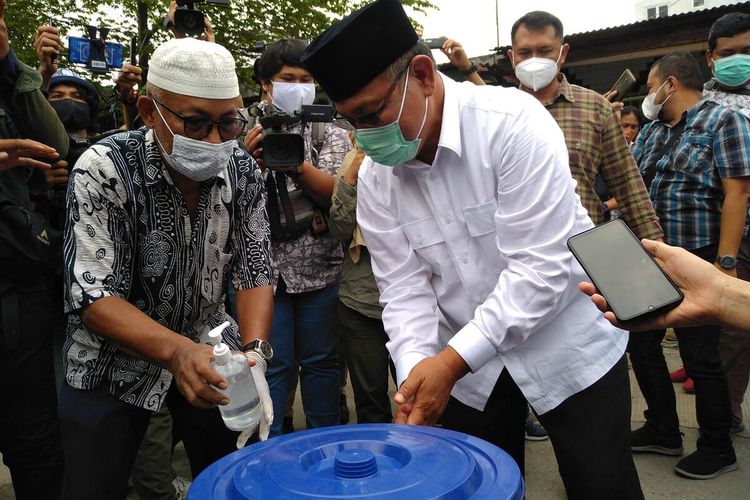 Calon Wali Kota Medan, Akhyar Nasution mencuci tangan sebelum mencoblos di TPS 22 di Kelurahan Brayan Darat II, Kecamatan Medan Timur. Akhyar yang tiba bersama keluarganya optimis memenangi pilkada ini.