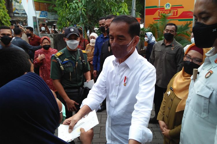 Presiden Joko Widodo (Jokowi) saat melakukan kunjungan kerja dan memberikan bantuan kepada warga di Gresik, Rabu (20/4/2022).