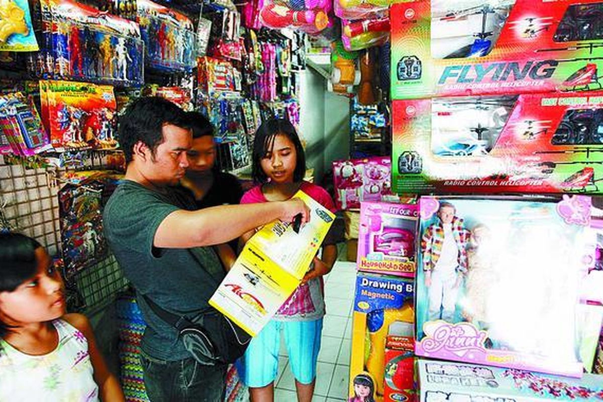 Pengunjung memilih mainan yang dijual pedagang di Pasar Gembrong, Jakarta Timur, Senin (7/7). Jika dibandingkan dengan hari biasa, selama liburan sekolah kali ini, omzet penjualan berbagai jenis mainan di pasar tersebut meningkat hingga 20 persen.  