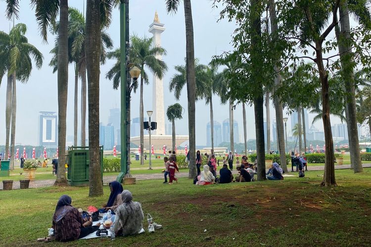 Suasana pengunjung Monas di siang hari, Sabtu (7/6/2025), beberapa pengunjung tampak piknik di atas rumput.