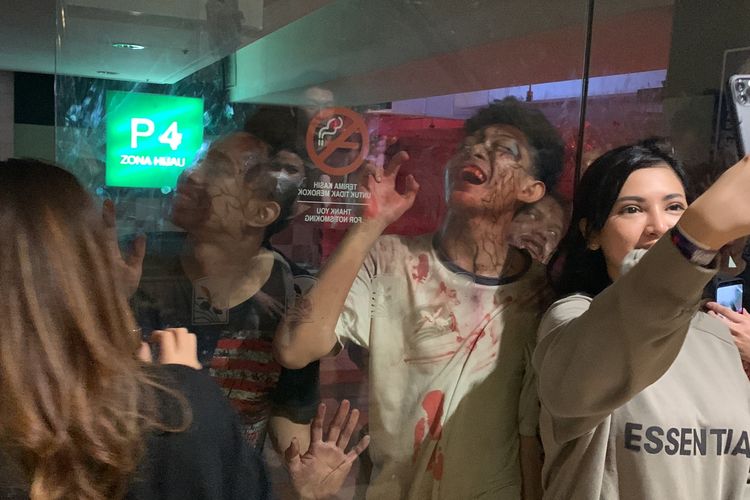 Seorang pengunjung berswafoto di wahana Zombie Apocalypse: Rise of The Dead, Kamis (19/1/2023). Wahana ini dibuka mulai 13 Januari 2022 di Mal Taman Anggrek, Grogol Petamburan, Jakarta Barat.