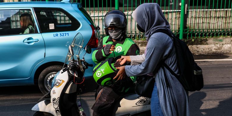 Pengemudi ojek online dengan penumpangnya melintas di Kawasan Stasiun Sudirman, Jakarta Pusat, Senin (8/6/2020). Pemerintah Provinsi DKI Jakarta mengizinkan pengemudi ojek online beroperasi untuk mengangkut penumpang selama PSBB transisi dengan menerapkan protokol kesehatan.