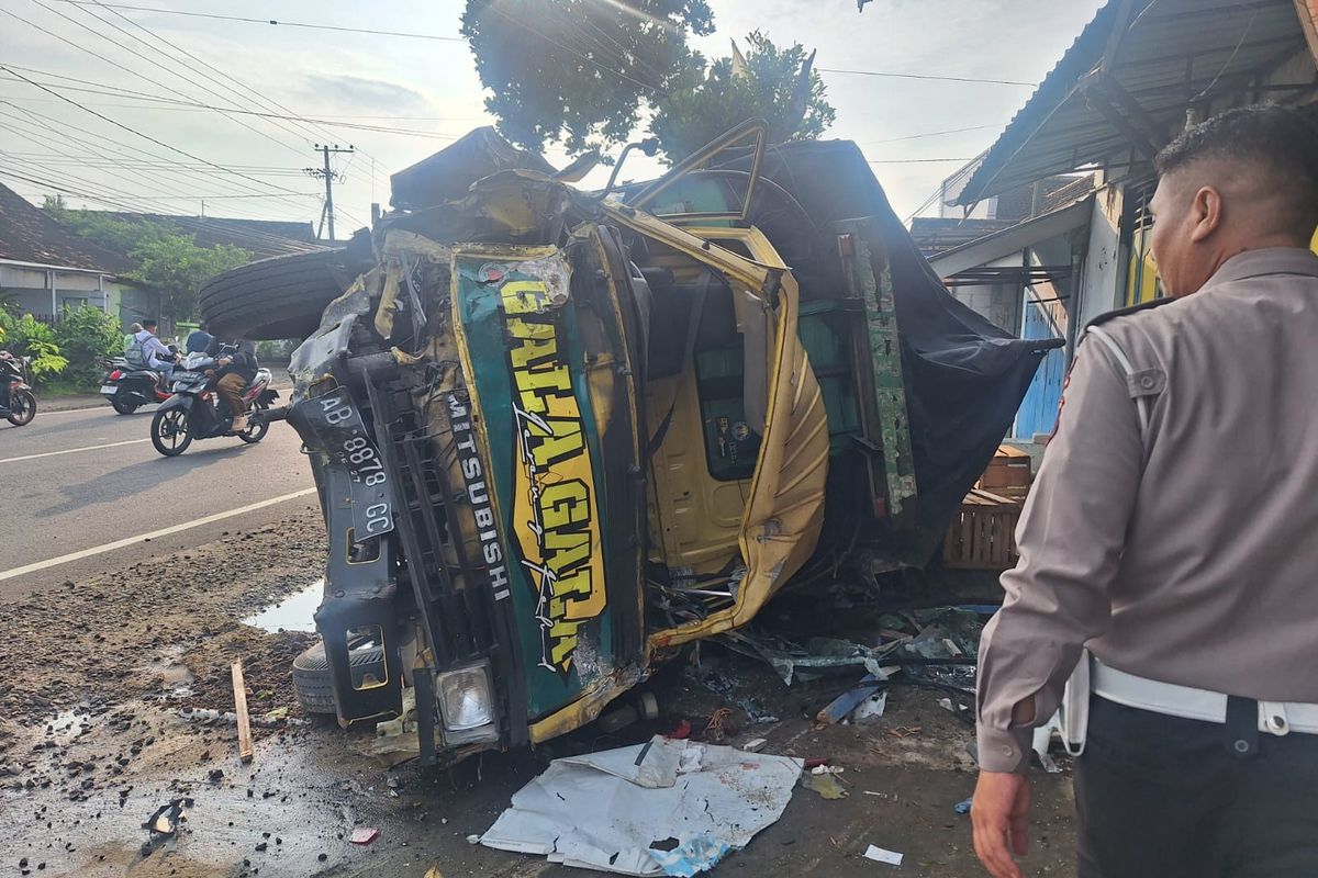 Petugas Satlantas Polres Kediri Kota memeriksa truk bak yang terguling usai menabrak dua kendaraan lainnya di Jalan Raya Kaliboto, Kecamatan Tarokan, Kabupaten Kediri, Jawa Timur, Selasa (14/1/2025).