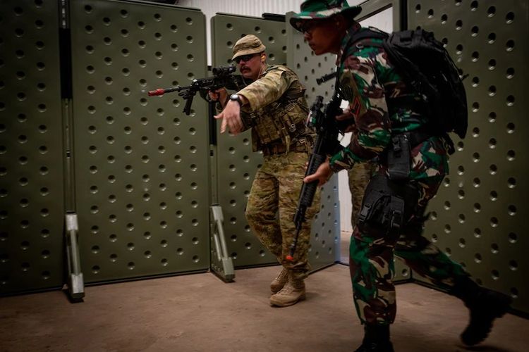 Latihan tempur gabungan TNI AD dan Angkatan Bersenjata Australia saat menggunakan senjata bertanda merah di ujung larasnya yang menunjukkan senjata tersebut tidak menggunakan peluru tajam. [ABC News/Che Chorley]