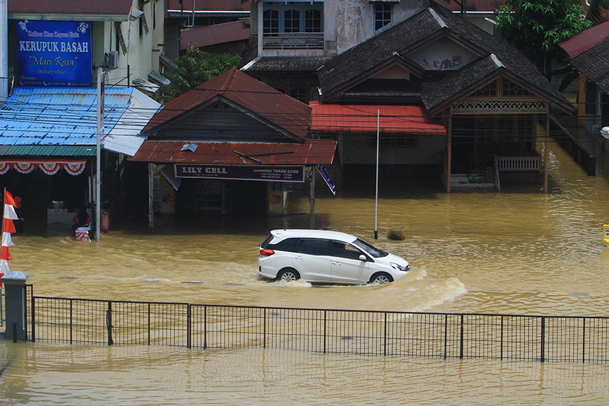 Sebuah mobil melintasi jalan yang terendam banjir di Kota Putussibau, Kabupaten Kapuas Hulu, Kalimantan Barat, Senin (14/9/2020). Banjir yang melanda Putussibau secara merata sejak Minggu (13/9/2020) kemarin tersebut terjadi akibat tingginya curah hujan selama beberapa hari terakhir hingga melumpuhkan aktifitas masyarakat di kota setempat.