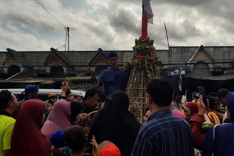 Warga berebut gunungan ruas bambu berisi makanan yang diarak, untuk mengharapkan keberkahan.