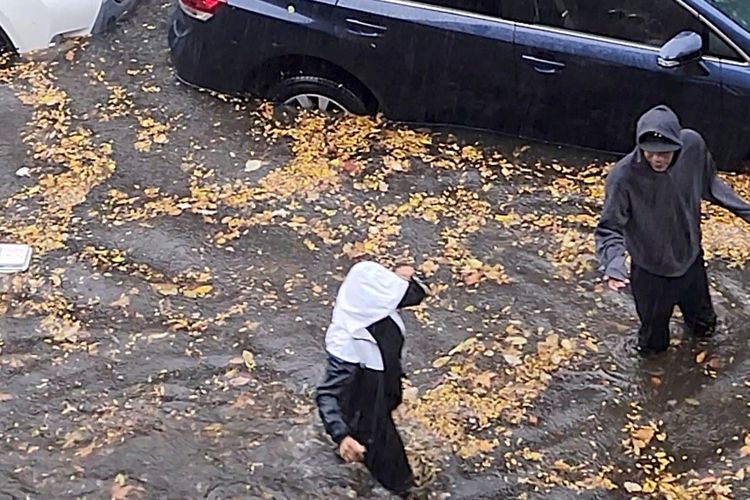 Penduduk berjalan melewati genangan banjir di New York, Amerika Serikat, Kamis (30/10/2025).