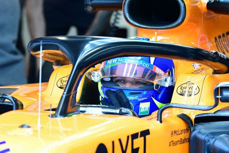 Lando Norris menggunakan helm dengan desain yang terinspirasi dari Valentino Rossi. (Photo by Miguel MEDINA / AFP)