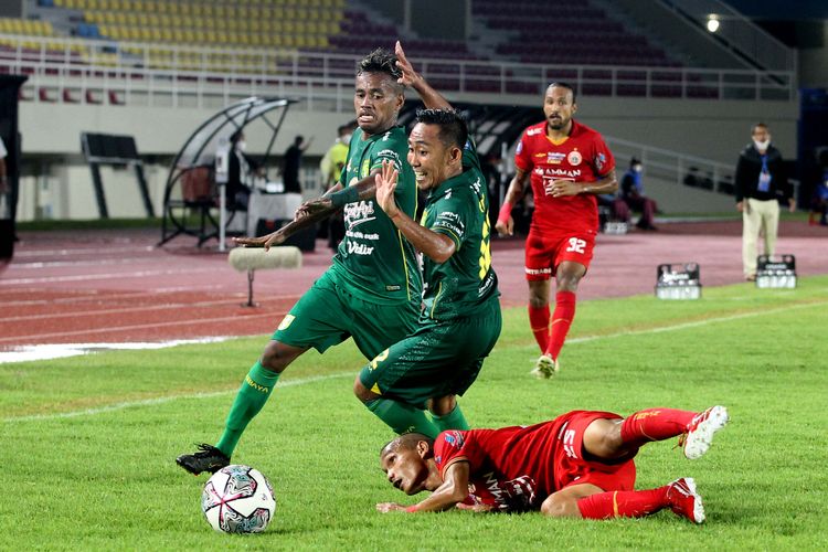 Pemain Persija Jakarta Riko Simanjuntak terjatuh saat berebut bola dengan pemain Persebaya Surabaya Alwi Slamat dan Rendi Irwan pada pertandingan pekan kesembilan Liga 1 2021-2022 yang berakhir dengan skor 0-1 di Stadion Manahan, Solo, Selasa (26/10/2021) malam.