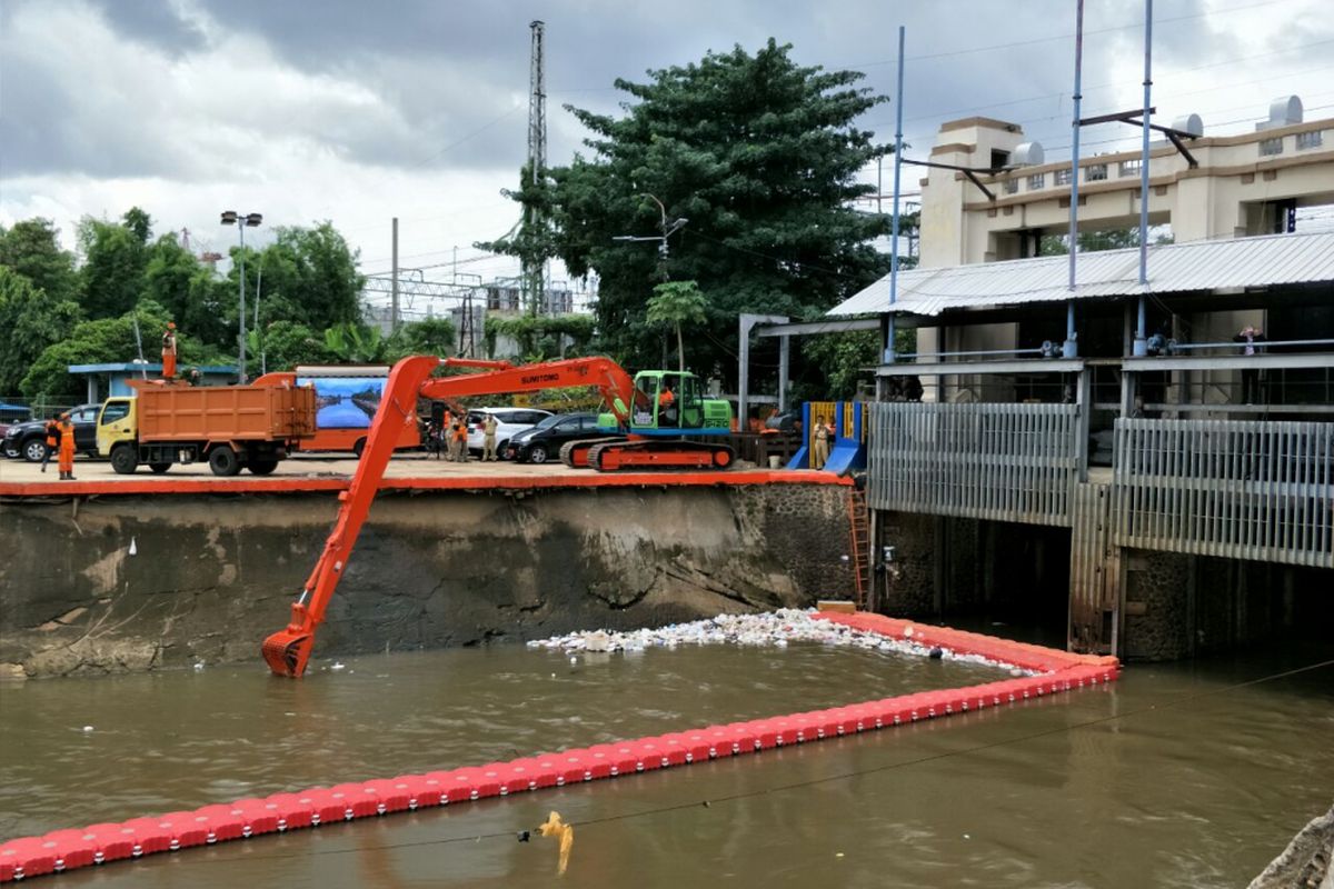 Alat berat mengangkut sampah yang menyangkut di Pintu Air Manggarai, Selasa (30/1/2018). 