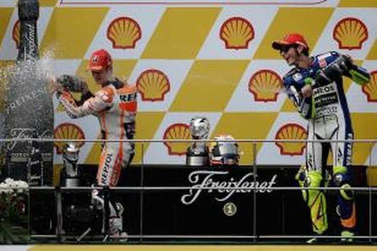 Pebalap Repsol Honda asal Spanyol, Dani Pedrosa (kiri), dan pebalap Movistar Yamaha asal Italia, Valentino Rossi, menyemprotkan sampanye untuk merayakan finis diurutan pertama dan ketiga mereka pada balapan GP Malaysia di Sirkuit Sepang, Minggu (25/10/2015).