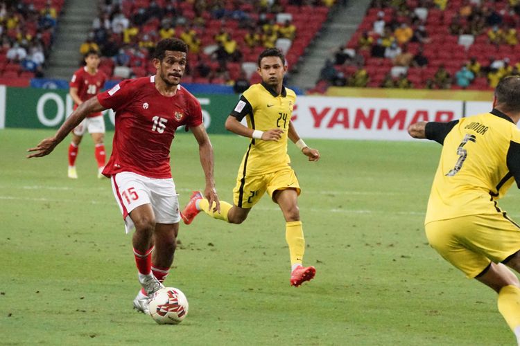 Pesepak bola Timnas Indonesia Ricky Kambuaya (kiri) berusaha melewati pesepak bola Timnas Malaysia Putera Nadher (kanan) dalam pertandingan grup B Piala AFF 2020 di National Stadium, Singapura, Minggu (19/12/2021). Indonesia menang dengan skor 4-1 dan lolos ke babak semifinal Piala AFF.