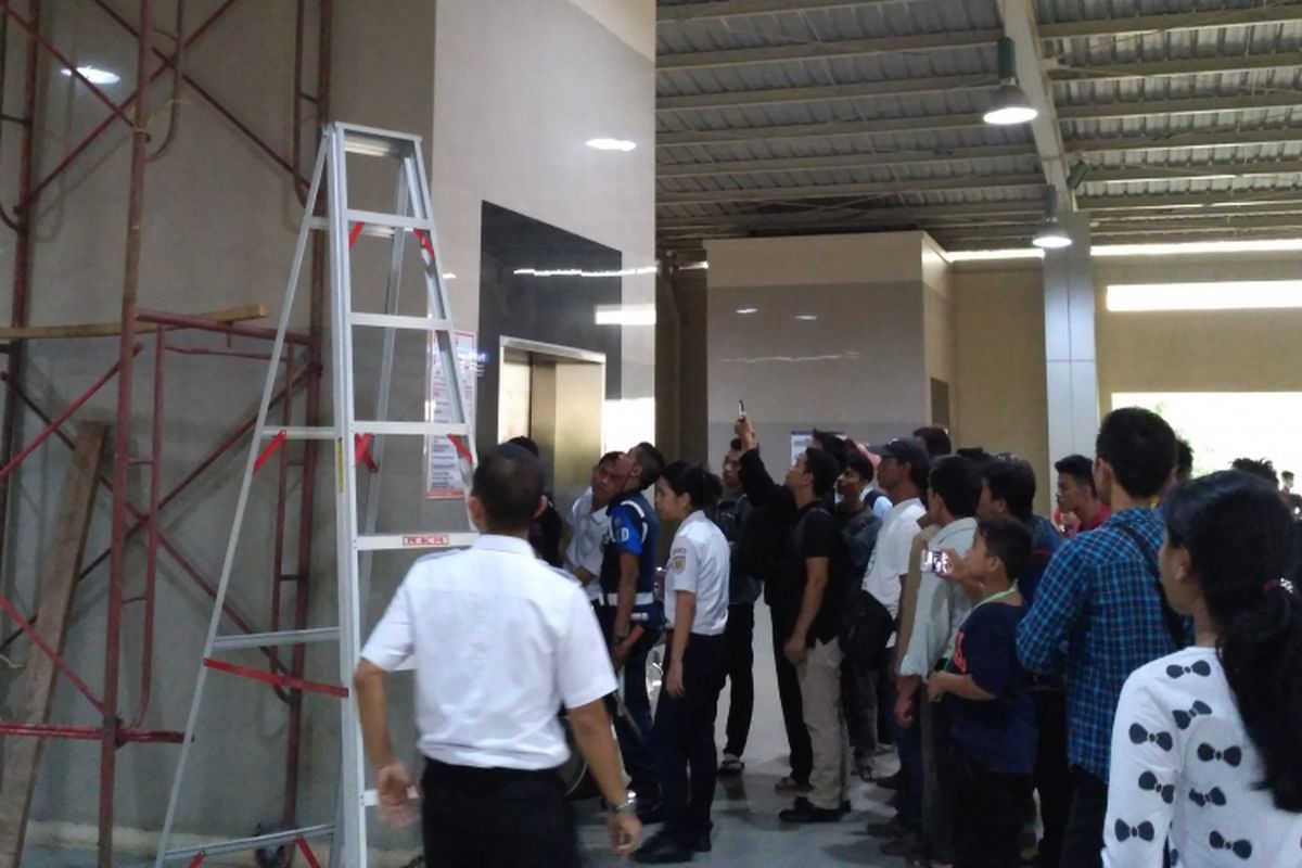 Sejumlah petugas di Stasiun Kebayoran berusaha membuka pintu lift untuk menyelamatkan tiga orang yang terjebak di dalamnya, Sabtu (1/4/2017).