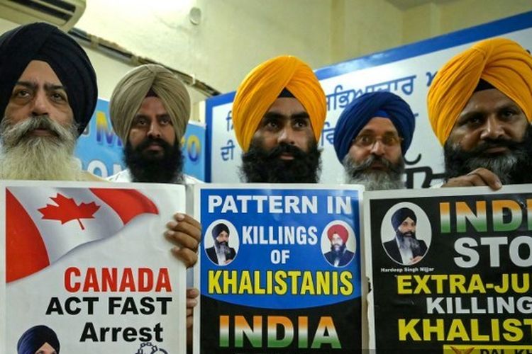 Kanwar Pal Singh (kiri) sekretaris Dal Khalsa, sebuah kelompok pro-Khalistan, bersama dengan para anggota dari berbagai organisasi Sikh memegang plakat yang menampilkan separatis Sikh, Hardeep Singh Nijjar di Amritsar pada tanggal 22 September 2023. Seorang aktivis untuk pembentukan tanah air Sikh yang merdeka yang disebut Khalistan, Hardeep Singh Nijjar dicari oleh pihak berwenang India atas dugaan terorisme dan konspirasi untuk melakukan pembunuhan, dan ditembak mati oleh dua penyerang bertopeng di dekat Vancouver pada bulan Juni. Sekretaris Dal Khalsa, Singh, mengklaim bahwa Nijjar bukanlah orang pertama yang dibunuh di luar hukum. Di mata umat Sikh, agen-agen India adalah tersangka utama, katanya kepada AFP.