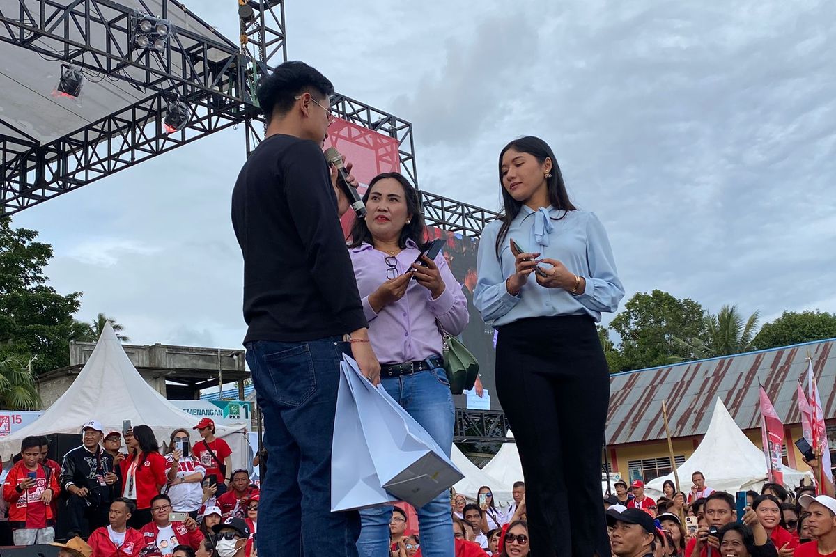 Ketua Umum PSI Kaesang Pangarep bersama istrinya, Erina Gudono, saat hendak memberikan hadiah ponsel kepada salah satu warga di sela-sela Kampanye PSI di Manado, Sulawesi Utara, Rabu (31/1/2024).