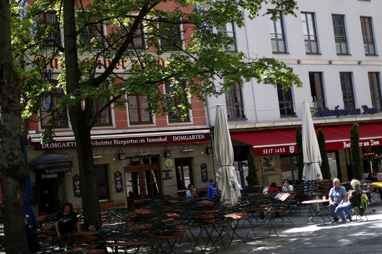 Orang-orang menikmati hari yang cerah di luar restoran tradisional Bavaria selama lockdown akibat virus corona di Munich, Jerman pada Sabtu (9/5/2020).