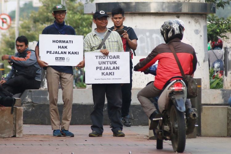 Sejumlah aktivis yang tergabung dalam Koalisi Pejalan Kaki menggelar aksi simpatik di kawasan Menteng Pulo, Jakarta, Jumat (21/7/2017). Aksi tersebut bertujuan untuk menuntut dikembalikannya fungsi trotoar bagi pejalan kaki.