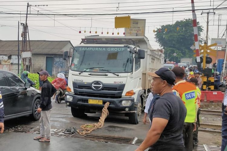 Sebuah mobil truk bermuatan pasir mengalami mogok di tengah perlintasan kereta api di Stasiun Serpong, Tangerang Selatan, Sabtu (17/2/2024) pukul 16.15 WIB. 