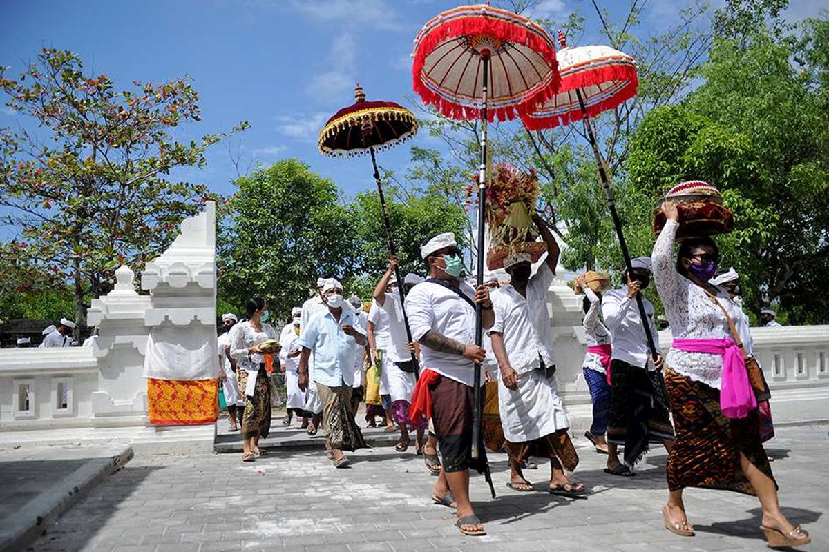 Warga membawa sejumlah sesaji saat perayaan Hari Raya Kuningan di Pura Sakenan di Pulau Serangan, Bali, Sabtu (26/9/2020). Hari Raya Kuningan yang digelar beberapa hari setelah Galungan ini dimaksudkan untuk merayakan saat Dewa-dewa dan leluhur kembali ke surga setelah bertemu keturunannya.