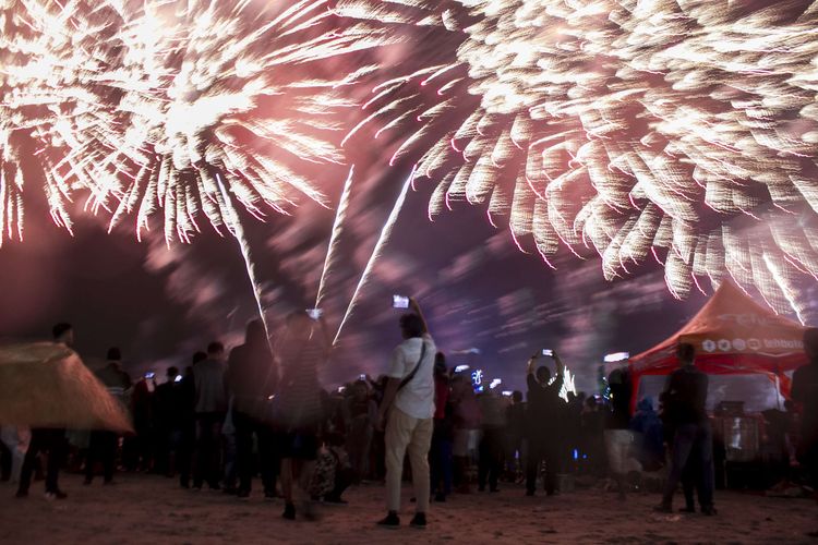 Pengunjung menyaksikan pesta kembang api terbesar The Biggest Jakarta Musical Fireworks yang digelar saat puncak malam pergantian tahun di Pantai Lagoon Ancol, Jakarta Utara (1/1/2020).Meski diguyur hutan lebat, animo masyrakat untuk merayakan tahun baru 2020 tidak surut.
