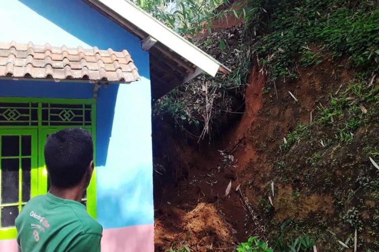 Seorang warga memerhatikan kondisi tanah yang merusak bangunan rumah warga dalam peristiwa pergerakan tanah di wilayah Kabupaten Cianjur, Jawa Barat.