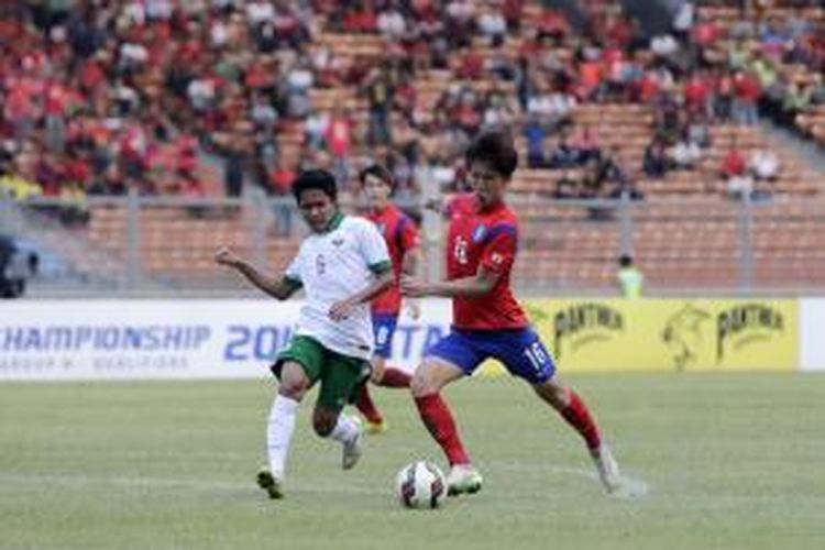 Pemain timnas Korea Selatan U-23 Lee Yeongjae berusaha melewati pemain timnas Indonesia U-23 Evan Dimas dalam laga kualifikasi Piala Asia U-23 Grup H di Stadion Utama Gelora Bung Karno, Senayan, Jakarta, Selasa (31/3/2014). Indonesia dikalahkan oleh Korsel dengan skor 4-0. 