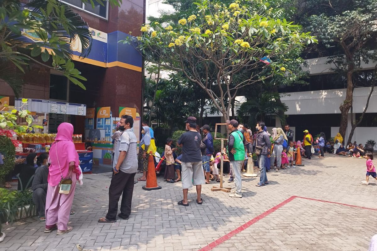 Antrean warga pemengang Kartu Jakarta Pintar (KJP) panjang dan mengular saat menunggu mendapatkan subsidi sembako di depan JP Mart, Kantor Walikota Jakarta Pusat, Selasa (15/8/2023). (KOMPAS.com/XENA OLIVIA)
