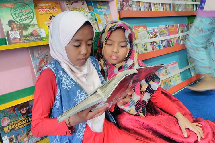 Anak-anak membaca di Taman Bacaan Masyarakat Rumah Pelangi di Desa Suci, Kecamatan Manyar, Gresik, Jawa Timur.