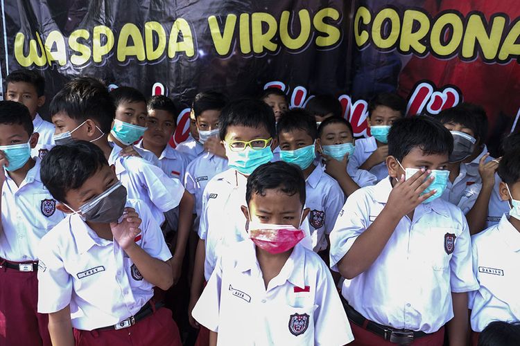 Siswa SD Islam Internasional Al-Abidin Solo memakai masker saat aksi peduli kesehatan bertajuk Waspada Virus Corona di halaman sekolah setempat, Solo, Jawa Tengah, Senin (3/2/2020). Aksi tersebut diisi dengan sosialisasi hidup sehat dan ajakan mendukung Warga China yang sedang menghadapi wabah Virus Corona untuk semangat.